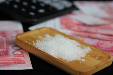 sugar on a wood plate on money background