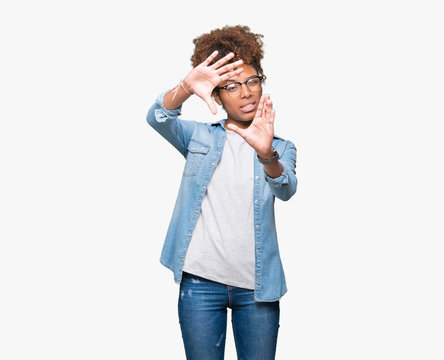 Beautiful young african american woman wearing glasses over isolated background Smiling doing frame using hands palms and fingers, camera perspective