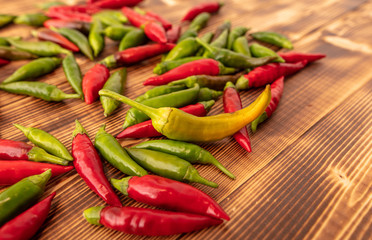 Green and red chili peppers on a wooden board