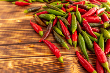 Green and red chili peppers on a wooden board