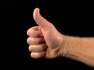 Thumb up, on a black background. A gesture with one finger, a sign of goodness.