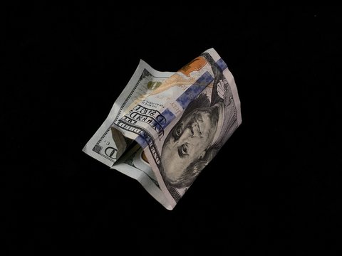 Crumpled one hundred american dollars on a black background. Bad American money, close-up. Concept: devaluation, falling currency, money trash.