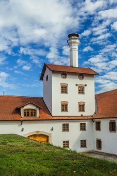 Dacice, Czech Republic - September 29 2019: View of former brewery building with white facade, red roof and a chimney on a sunny autumn day with bright blue sky and white clouds. Vertical image.