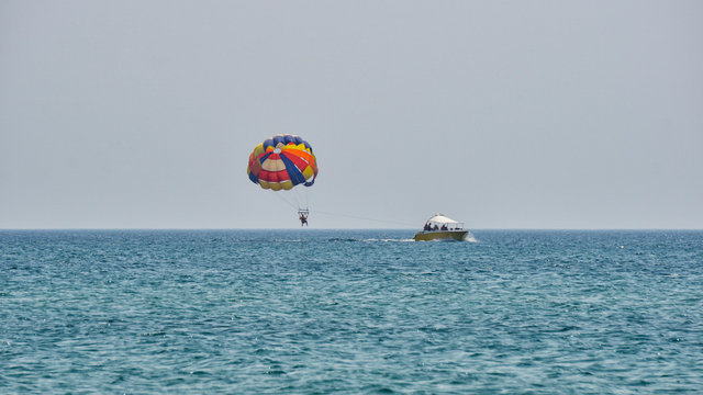 People on a parachute towed behind a boat