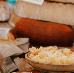 different cheese in packs and in bulk on market counter.