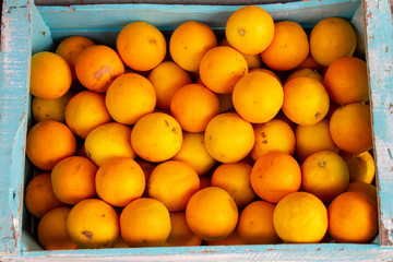 Blue box with fresh oranges just taken from the tree. Vitamin C concentrated in oranges, very nutritious and healthy fruits.