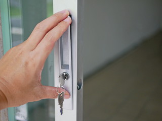 Close up of a key lock in a man's hand being installed on a sliding glass door