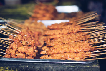 Two of the Philippine's street food on aluminium plate - the deep fried breaded chicken and 