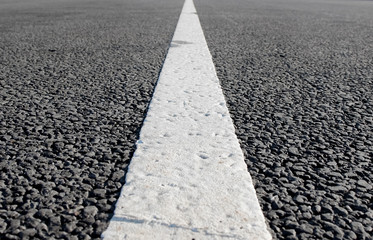 Obraz premium An empty road with single solid white line road marking. Background photo in perspective with selective focus