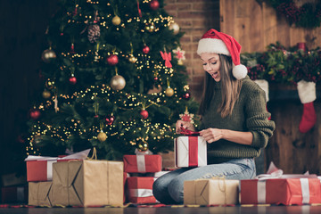Wow its for me. Full length photo of excited emotional girl sit floor checkered plaid blanket get gift box for christmas enjoy newyear noel present wear santa claus headwear in house indoors