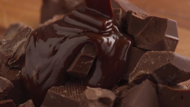 Melted chocolate pouring over chunks of chocolate