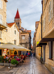 Narrow street in historic town Trogir, Croatia. Travel destination. Narrow old street in Trogir city, Croatia. The alleys of the old town of Trogir are very picturesque and full of charm. Croatia.