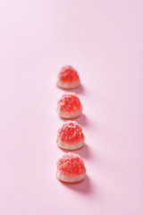 Sweet jelly candy lined up on a pink background