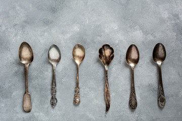 Vintage tea spoons on grey background. Flat lay