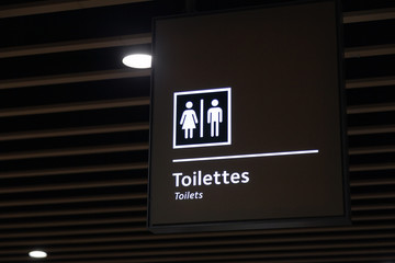 Label of symbol of toilet for men and women on blue plate, direction  sign and navigation pointer WC restroom in building, airport, station
