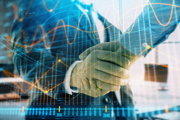 Multi exposure of financial graph on office background with two businessmen handshake. Concept of success in business