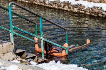 A woman bathes in the river in winter