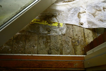 Construction work on old brick house with scaffolding, tarps, cement etc