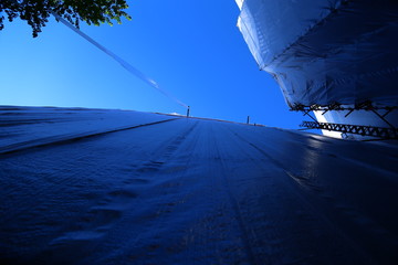 Construction work on old brick house with scaffolding, tarps, cement etc