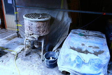 Construction work on old brick house with scaffolding, tarps, cement etc