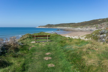 A bench with a scenic view of Combesgate beach at Woolacombe in Devon , England