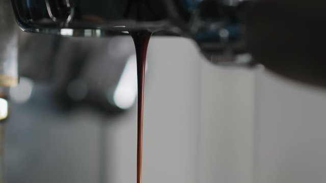 Slow motion closeup of espresso extraction with bottomless portafilter