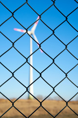 Windkraftanlage hinter einem Zaun in einem Industriegebiet in Magdeburg