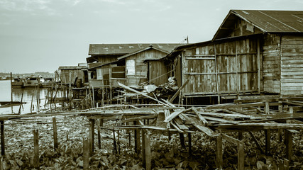 slum wooden houses on the riverbank of Mahakam, Samarinda, Borneo, Indonesia. monochromed