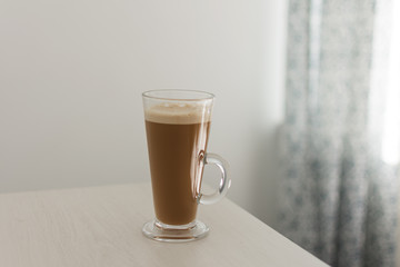 Long glass cup of cappuccino on coffe latte.