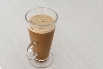 Long glass cup of cappuccino on coffe latte.