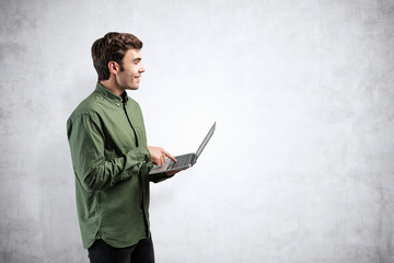 Smiling casual young man with laptop, mock up