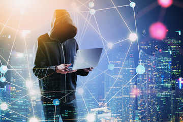 Hacker with laptop in night city, network
