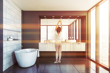 Young woman in luxury gray and wooden bathroom