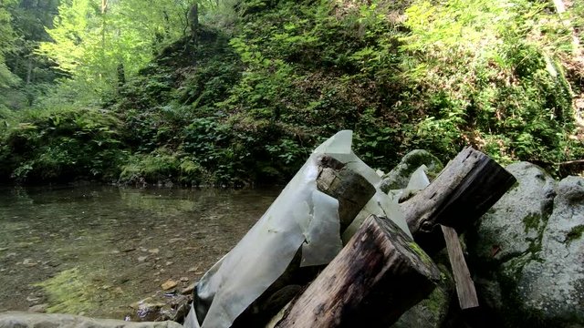 4K Small natural pond in pristine nature with plastic garbage