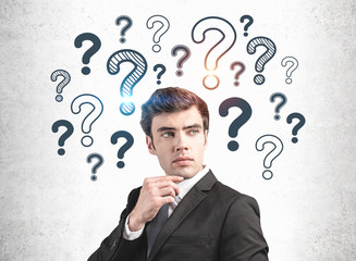 Thoughtful businessman and question marks