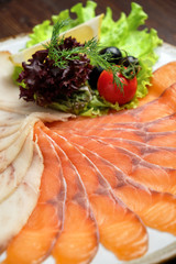 White and red fish sliced in thin slices on a brown wooden background. restaurant menu