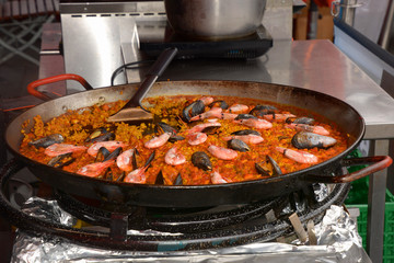 traditional shrimp paella in cooking pan, seafood paella with shrimps and mussels in a cooking pan