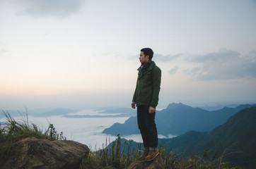 Obraz premium young man standing on hill is wearing green coat