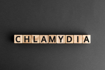 Chlamydia - word from wooden blocks with letters, parasitic bacterium chlamydia concept, grey background