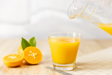 Close up Pour oranges juice into the glass on the table wooden. fruit fruits drink