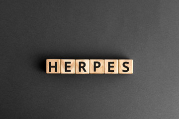 Herpes - word from wooden blocks with letters, viral diseases herpes viruses concept, grey background - obrazy, fototapety, plakaty