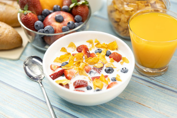 Healthy breakfast. bread, orange juice, strawberry, blueberries, milk and cereal in bowl on wooden table. Healthy food