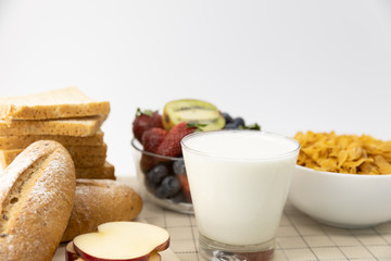 Healthy breakfast. bread, strawberry, blueberries, kiwi, milk and cereal in bowl on mat background. Healthy food