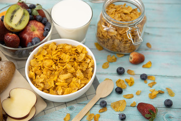 Healthy breakfast. bread, fruit, strawberry, blueberries, kiwi, milk in glass and cereal in bowl on mat and wooden table. Background Healthy food.