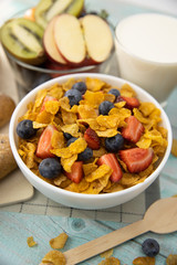 Healthy breakfast. bread, fruit, strawberry, blueberries, kiwi, milk in glass and cereal in bowl on mat and wooden table. Background Healthy food.