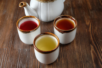 Different tea in teapots on a dark wooden background. catering menu