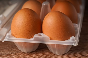 A carton of eggs on a wooden background