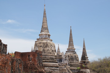 Fototapeta premium Asian religious architecture. Ancient pagoda at Wat Phra Sri Sanphet temple under blue sky. Ayutthaya, Thailand