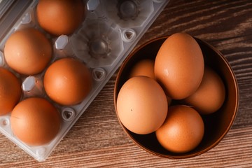 A carton of eggs on a wooden background