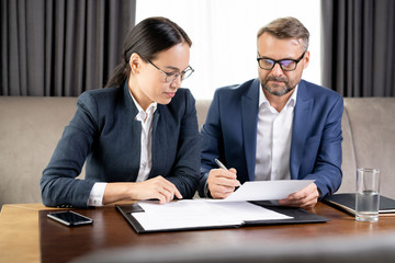 Confident businessman showing his business partner where to sign contract